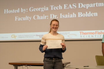 Katie Slenker holding an award and looking happy
